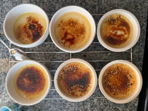 six ramekins of creme brulees on a wire rack